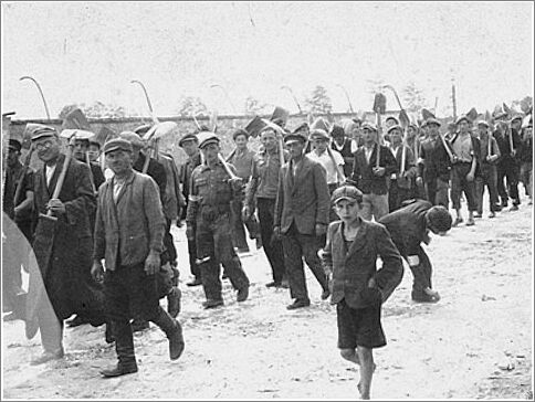 A group of Jewish men and youth from Zarki march to a forced labor site carrying shovels